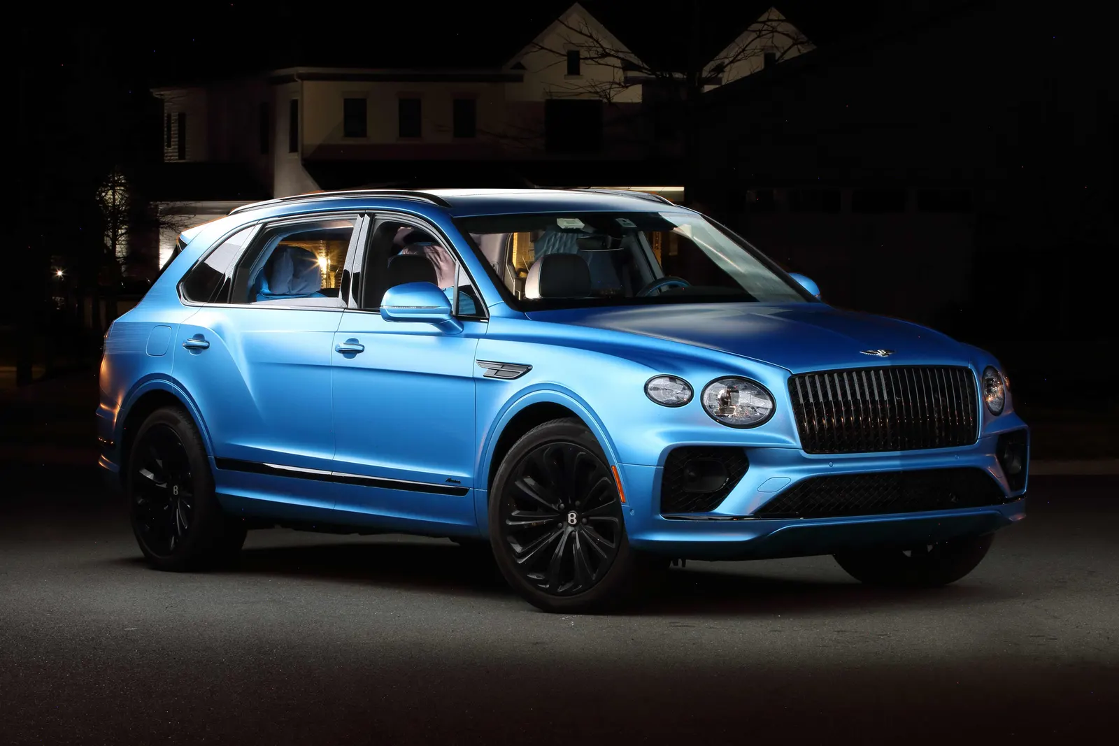 Satin blue Bentley Bentayga on black wheels photographed at night