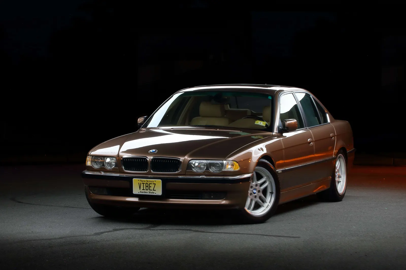 Bronze BMW E38 7 Series photographed against a black background