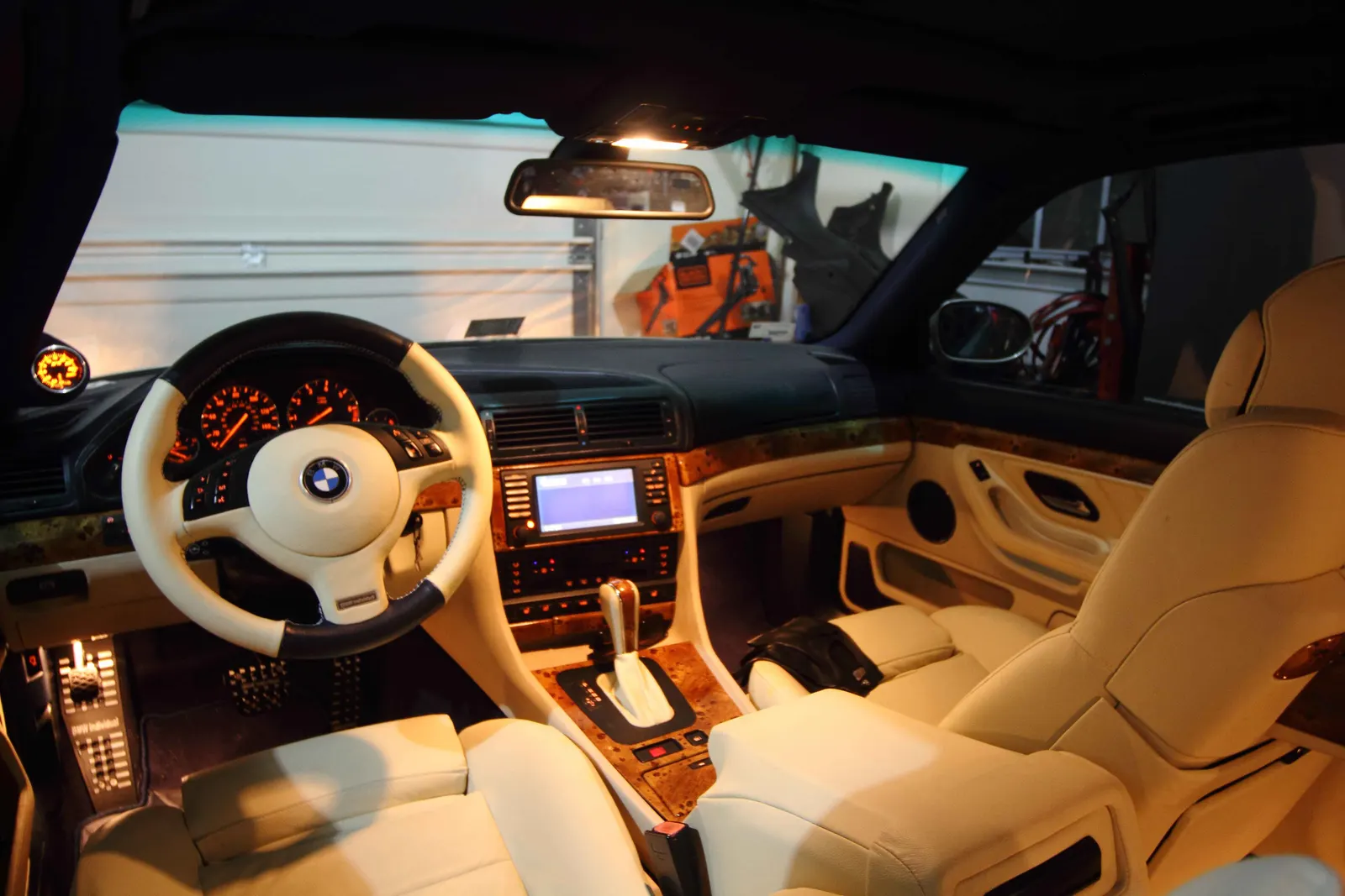 Cream leather BMW E38 cockpit with a two-tone steering wheel and burl wood trim